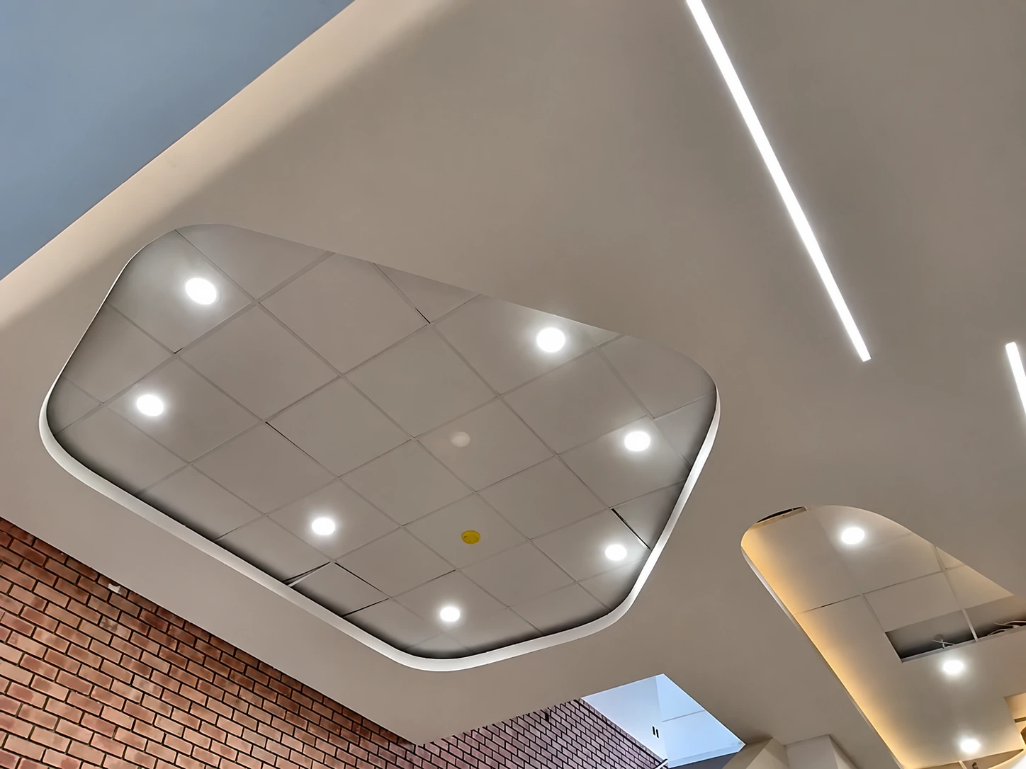 Curved feature ceiling with recessed downlights and linear lighting