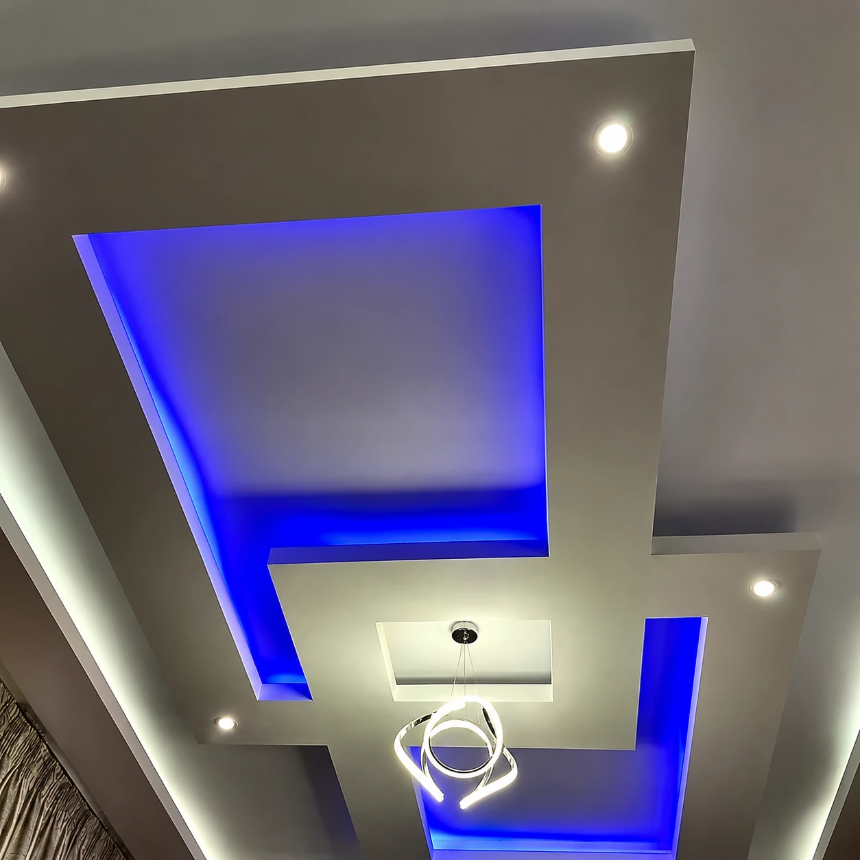 Residential feature ceiling with blue cove lighting and sculptural pendant