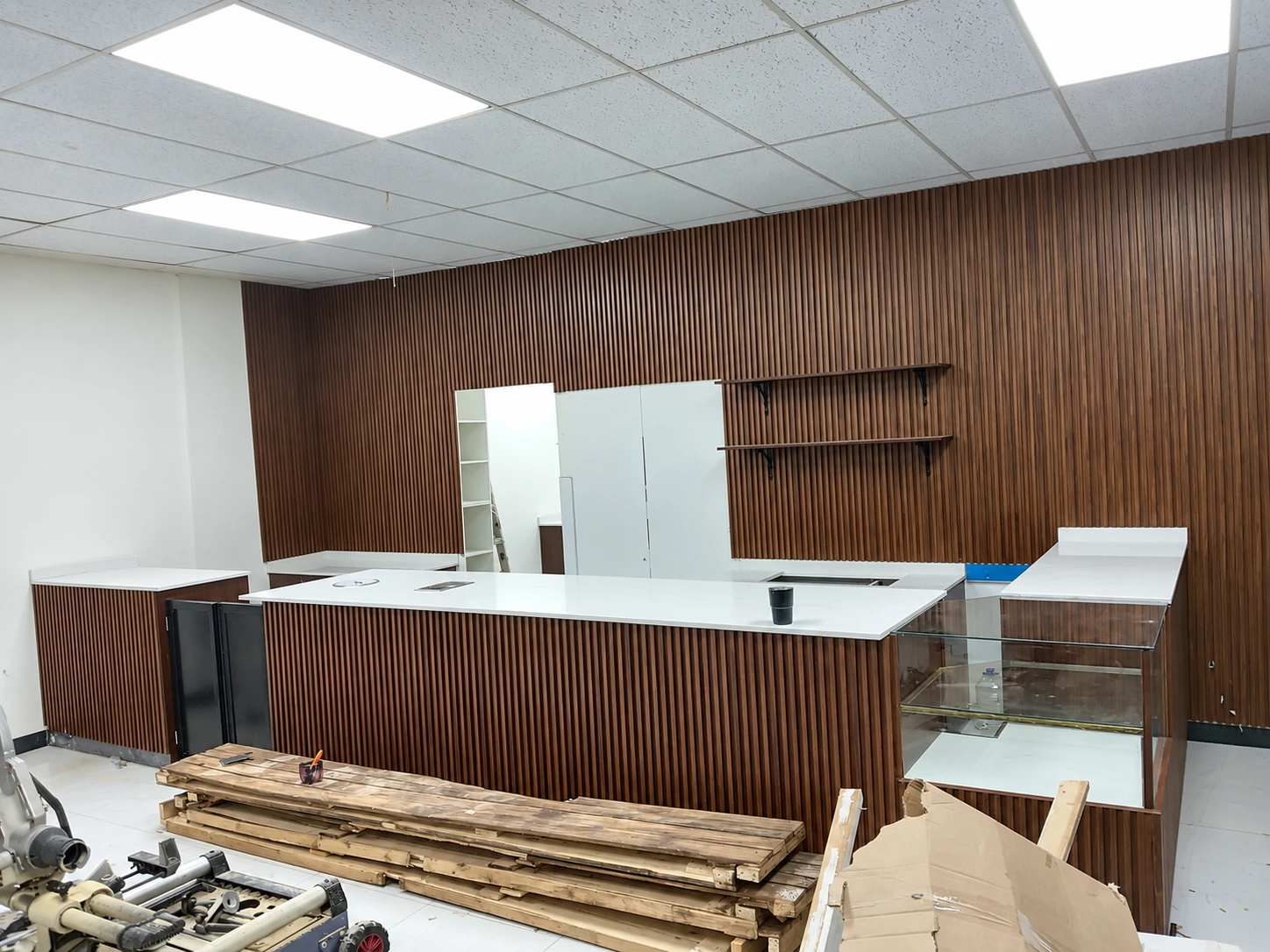 Reception counter, timber slat wall and suspended ceiling during interior fit-out